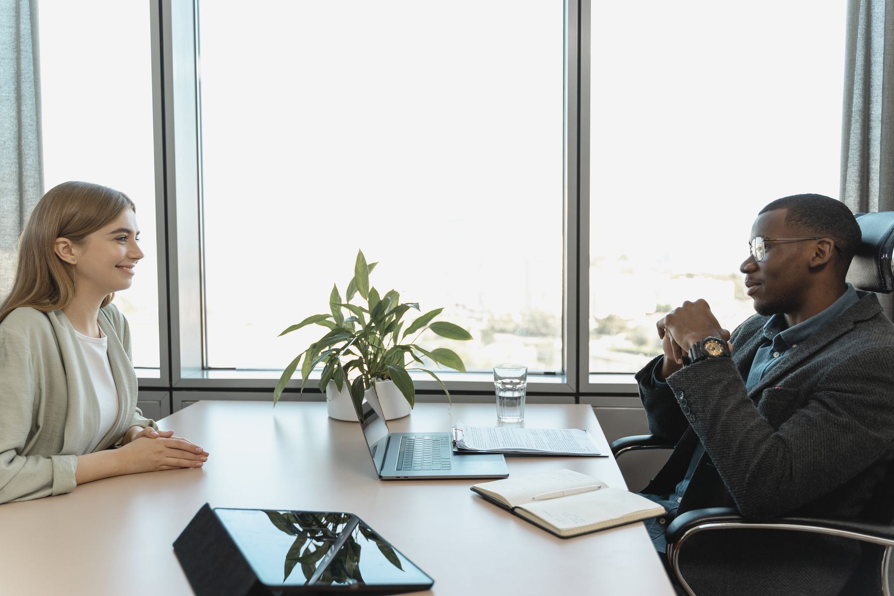 Entrevista de selección en una sala luminosa: una candidata y un consultor conversan